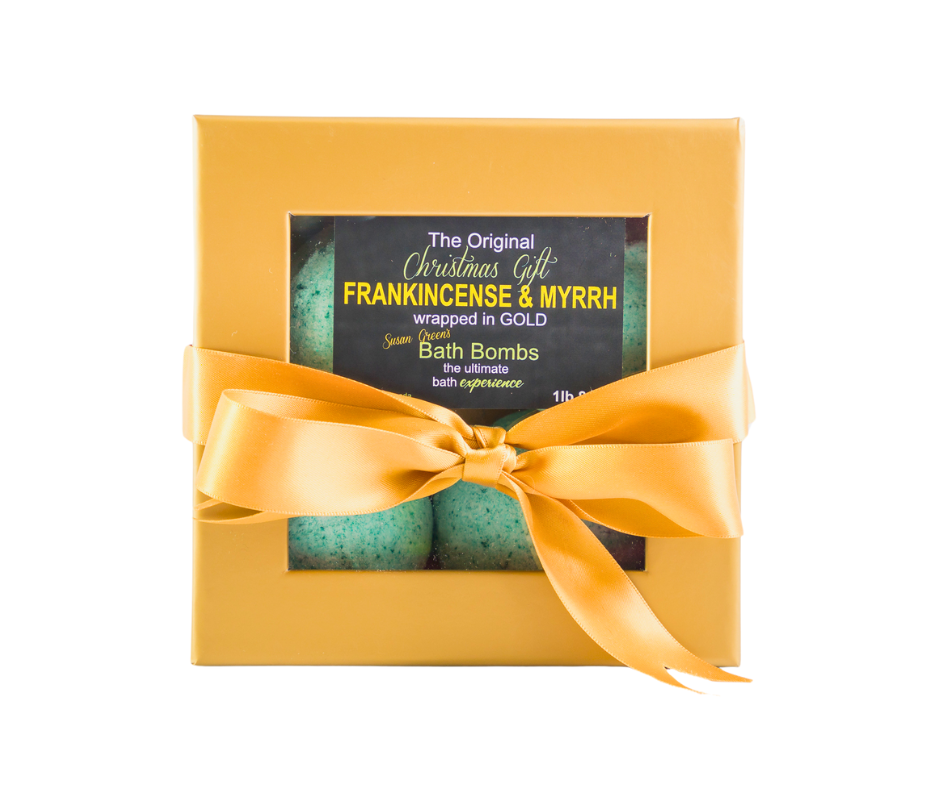 Bath bombs in a gold box with a yellow ribbon on a white background