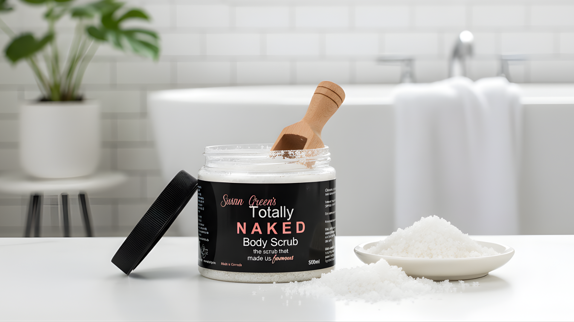 Jar of 'Totally Naked' body scrub with a wooden scoop on a bathroom counter.